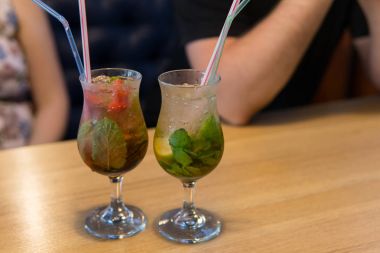 İçecek buzlu cam Kupası arka plan yaz kafeterya masada duruyor. Taze soğuk mojito ahşap bir masaya kokteyl