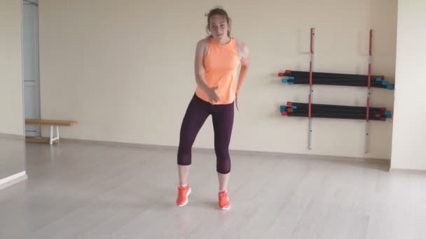 Chica joven bailando zumba en gimnasio o estudio. fitness, deporte, danza y estilo de vida — Vídeo de stock