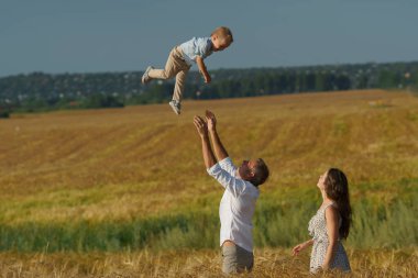 Genç anne ve çocuk buğday alanda yürüyüş