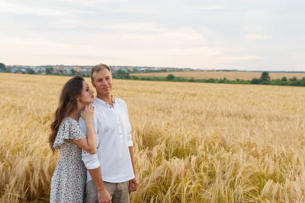 Mulher abraços homem, casal andando em um campo de trigo — Fotografia de Stock