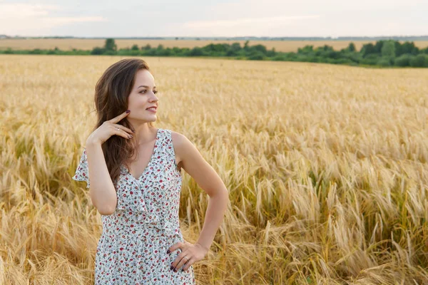 Jovem mulher de vestido no campo de trigo de verão — Fotografia de Stock