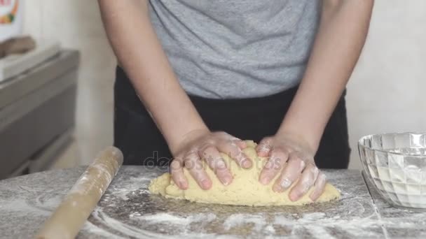 Baker mains pétrissant la pâte dans la farine sur la table