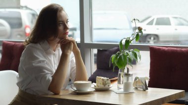 Güzel kız hoş kokulu kahve ve tatlı kek kahve evde oturan sahiptir. İş kadını dinlenme molası sırasında