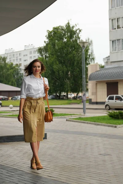 Belle brune jeune femme en robe et marchant dans la rue — Photo