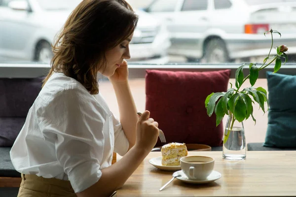 Eine junge schöne Frau, die in einem Café Kaffee trinkt. junge Frau in Businesskleidung in der Mittagspause — Stockfoto