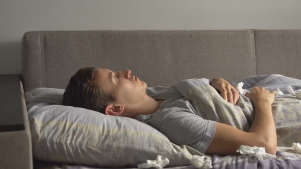 Primer plano de enfermo joven caucásico hombre es dormir en la cama — Vídeo de stock