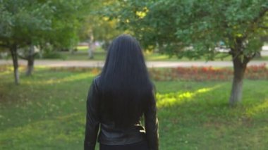 genç güzel kız yürüyüş ve güneşli yaz park arka plan üzerinde etrafında döner