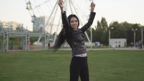 Glad flicka i solig sommar park öppnar händerna åt sidorna medan promenader i parken — Stockvideo