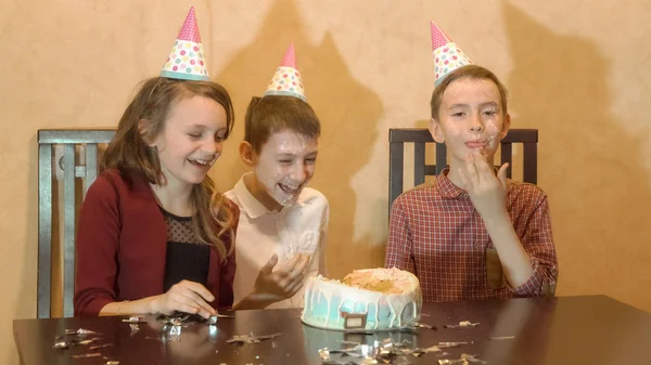 Crianças despreocupadas em uma festa de aniversário. amigos afundou rosto no bolo de aniversário . — Fotografia de Stock