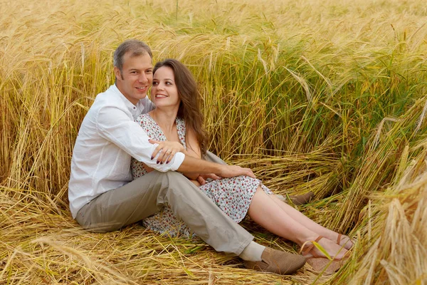 Homem abraça mulher em um campo de trigo, casal de amor — Fotografia de Stock