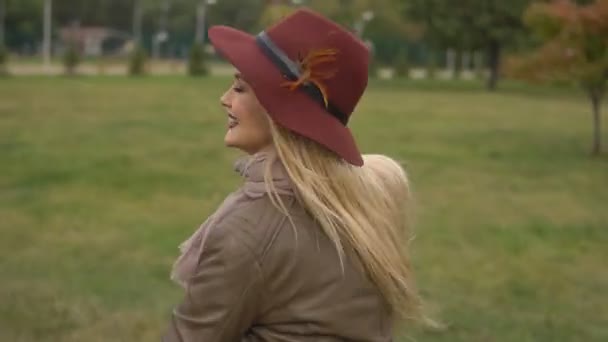 Belle fille blonde marchant dans le parc — Video