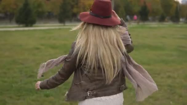 Mooi blond meisje lopen in het park — Stockvideo