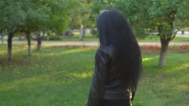 genç güzel kız yürüyüş ve güneşli yaz park arka plan üzerinde etrafında döner