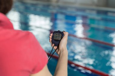 Kronometre havuz eğlence merkezinde tutarak Yüzme antrenörü.