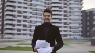 Belgeler Ofis Binası karşı açık dışarı atmak mutlu genç iş adamı siyah takım elbise