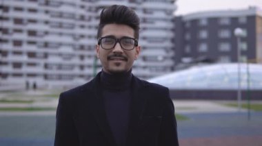Gözlük ve kameraya arıyor genç çekici işadamı portresi. Gülümseyen ve başparmak yukarıya, ağır çekim yapma dostum