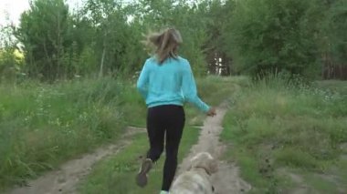 genç kız ormana doğru safkan köpeğiyle sıcak yaz günü çalışır.