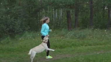 genç kız ormana doğru safkan köpeğiyle sıcak yaz günü çalışır.