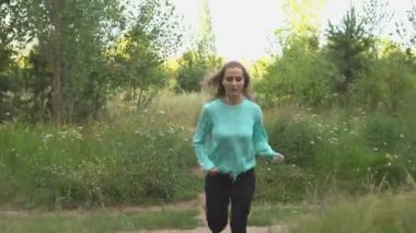 Genç kadın ile köpek ormanda yürüyor