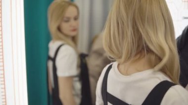 Güzel kız Oda uydurma içinde ayna üzerinde elbise görünüyor