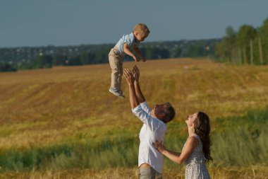 Genç anne ve çocuk buğday alanda yürüyüş