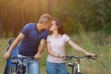 Ormanda, romantik öpüşme çift bisiklet üzerinde yürümek