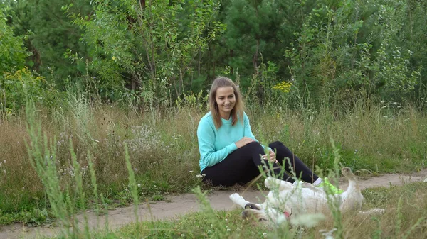 Junge Frau geht mit Hund im Wald spazieren — Stockfoto