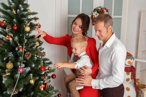 Feliz familia decorando el árbol de Navidad. — Foto de Stock