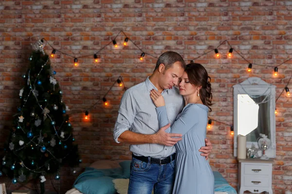 Mladý pár milující na pozadí vánoční stromeček — Stock fotografie
