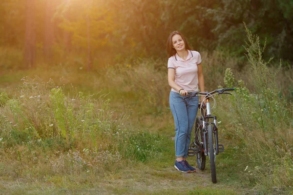 Молодая девушка на велосипеде в лесу . — стоковое фото