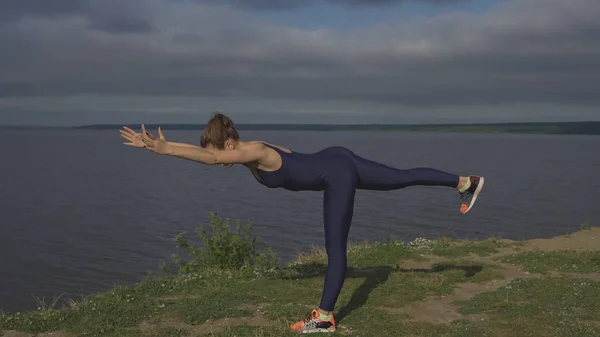 Woman standing on one leg, balance training, yoga