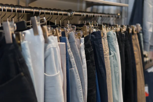 Pantalones y jeans en los bastidores de la tienda de ropa — Foto de Stock