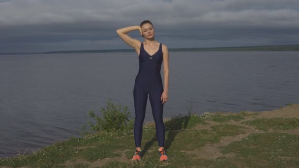 Yoga femme en bleu vêtements de sport étire en plein air . — Video