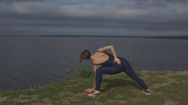 Flicka i blå sportkläder, yogi praxis utomhus. — Stockvideo