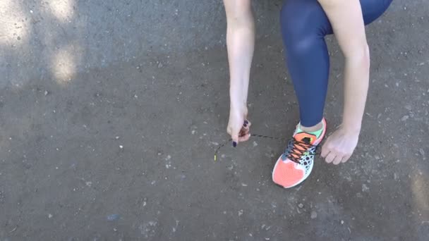 Женщина, завязывающая шнурки на кроссовки . — стоковое видео