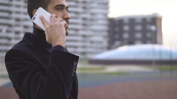 Счастливый умный бизнесмен разговаривает по телефону на открытом воздухе в офисном здании — стоковое видео