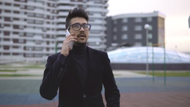 Genç yakışıklı işadamı cep telefonda konuşurken — Stok video