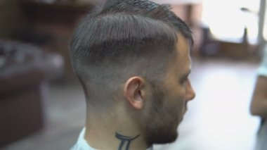 Ana kesim saç ve sakal Berber Dükkanı'nın adamlarından, Kuaför saç modeli için genç bir adam yapar.