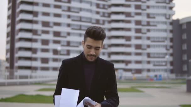 Attractive young businessman throw out documents outdoor. — Stock Video
