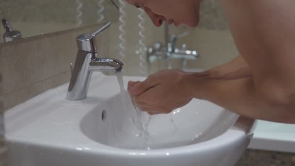 Hombre joven está lavando en el baño — Vídeos de Stock