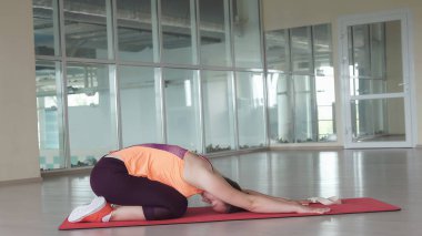 Sevimli kadın atlet spor mat spor eğitim sırasında zor germe egzersiz yapar