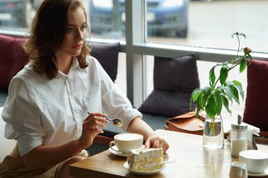 bir kafede kahve içme genç güzel bir kadın. Öğle tatilinde iş giysili genç kadın