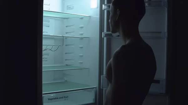 Uomo affamato è alla ricerca di cibo da mangiare in frigorifero vuoto di notte . — Foto Stock