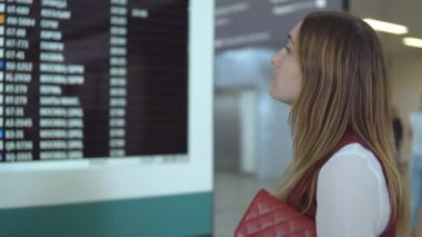 Güzel beyaz kız standları ve seçim uçuş fark ile bulanık çetele arka plan üzerinde.