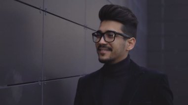 Beyaz işadamı başı döner ve ofis binası duvara yakın gülümsüyor portre genç yakın çekim