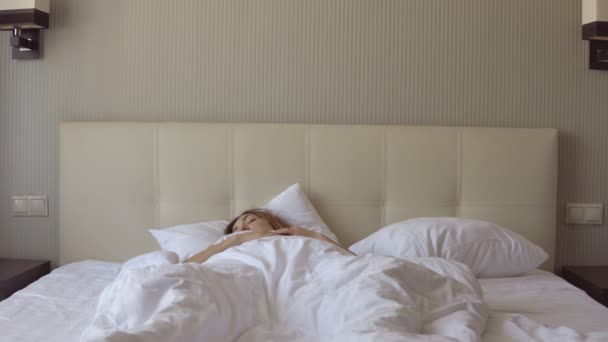 Fiatal gyönyörű álmos lány hirtelen felébredt, és leült az ágyra. — Stock videók