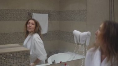 Güzel kız havlu ayakta alarak duş sonra aynanın önünde dans