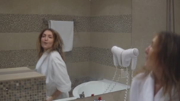 在镜子前面跳舞的俏丽的女孩在浴站立在毛巾以后 — 图库视频影像