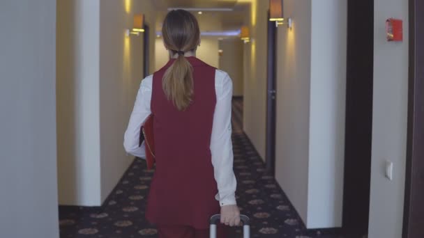 Mulher com sacos caminha pelo corredor até seu quarto — Vídeo de Stock