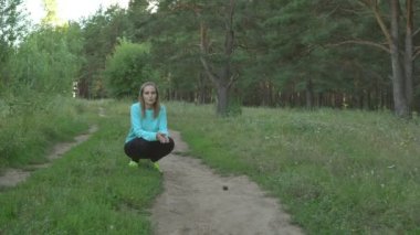 Güzel kız köpeğini eğitiyor ve çim Park'ta oturuyor ve incelik ile onu teşvik eder